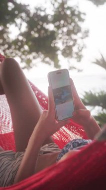 Genç bir kız, dışarıda huzurlu bir şekilde eğlenirken, hiç zorlanmadan telefonuna bir fotoğraf yapıştırıyor.