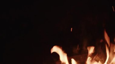 Yakacak odun gece ateşinde parlak bir şekilde yanar, parlak alevler çatırdar ve karanlıkta sıcak bir parıltı yayar.