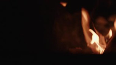Sakin bir kamp ateşi karanlık gece gökyüzüne duman yayarak sakin ve atmosferik bir manzara yaratıyor.