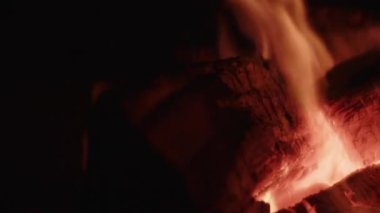 Yanan odunlara yakın çekim, parlak, canlı alevler, yoğun ısı ve titreşen dinamik parlaklığı vurguluyor.