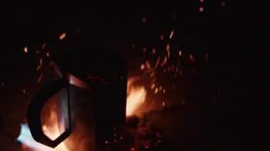 Alev makinesinden gelen güçlü bir ateş topu delinmiş bir ateş çukurunu ateşler, geceyi yoğun alevler ve parlayan közlerle aydınlatır.