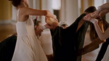 Farklı beyaz ve siyah kostümlü dansçıların etkileyici ve senkronize bir şekilde dans ettiği süslü bir balo salonunda çağdaş bir dans gösterisi.