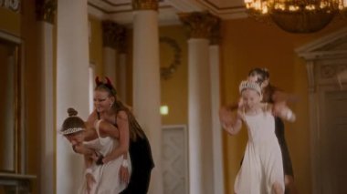 Genç dansçılar iyi ve kötünün temasını anlatan çağdaş bir gösteri sergilerken, akıcı beyaz elbiseler içindeki kişiler saflığı ve maskeli dansçıları simgeliyor.