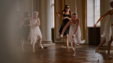 Yüksek sütunları ve altın aksanıyla büyük balo salonunda genç dansçılar, akıcı beyaz elbiseli ve tacını takmış genç bir kızın hareketlerine enerjik bir şekilde önderlik ettiği etkileyici bir gösteri sergiliyorlar.