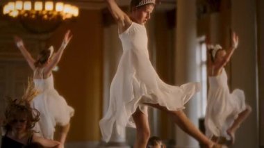 Dinamik bir çağdaş dans performansı, dansçıların hareketli, havanın ortasında, zıt giyinen beyaz elbiseleri ve çarpıcı siyah elbiseleriyle canlı bir görsel dengeyi simgeleyen dansçılarla ortaya çıkar.