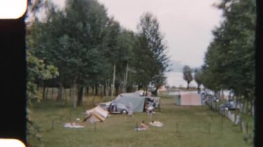 Como Gölü 'nün sakin kıyılarına çadır kuran bir ailenin 8 mm' lik görüntüsü. Huzurlu sahil manzaralı rahat bir kamp alanı oluşturuyor.