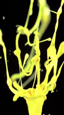 Siyah arkaplana karşı ağır çekimde yayılan parlak sarı boya çarpıcı ve dinamik bir görsel etki yaratıyor.