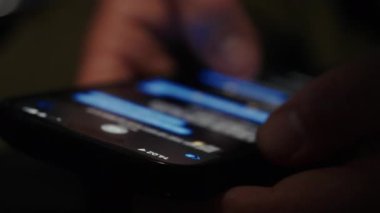 Bir kişi dokunmatik ekranlı akıllı telefondaki SMS mesajlarına göz atar, metin konuşmalarını geçirir