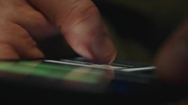 Bir kişinin eli cep telefonu ekranındaki sohbet konuşmalarını kaydeder, kısa mesajları tarar