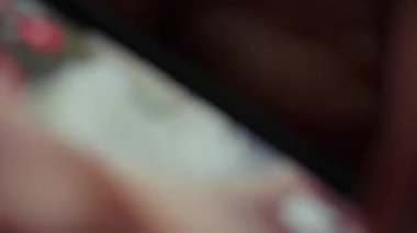 Bir kişi akıllı telefon ekranındaki sosyal medya güncellemelerini tarar, iletiler ve içeriklerle bağlantı kurar