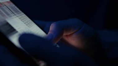 Bir kişinin parmağı akıllı telefon ekranında video ve fotoğraf küçük resimlerini tarıyor, dijital bir medya galerisinde geziniyor