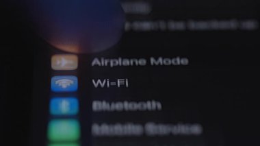 Aygıt ayarları arayüzünü gösteren ve parmakları seçenekler arasında gezinen dokunmatik ekranlı bir telefonun yakın plan görüntüsü