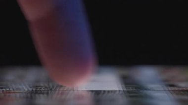 Bir cep telefonu galerisinde gezinen, dokunmatik ekrandaki fotoğraf ve resimlere göz atan bir parmağın yakın çekimi