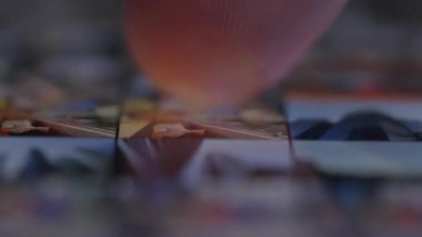 Cep telefonu ekranında fotoğraf ve videolara göz gezdiren, medya dosyalarını karıştıran bir kişinin yakın plan görüntüsü