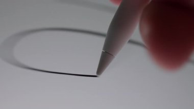 Dokunmatik ekran tabletine spontane, yaratıcı karalamalar yapmak için stil kullanan bir elin yakın çekimi