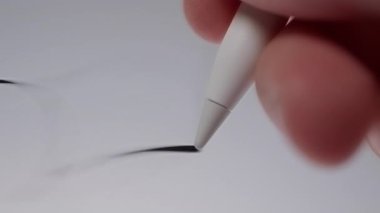 Dijital dokunmatik ekranda dinamik bir şekilde çizmek ve soyut çizgiler oluşturmak için bir stil kullanarak bir elin yakın plan çekimi, akışkan hareketi ve yaratıcı ifade