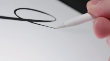 Tablet yüzeyine bir stilus çizerek hızlı ve dinamik dijital çizimleri gösteren hızlı bir karalama hareketinin yakın çekimi
