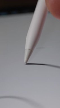 Stylus 'u tutan ve dokunmatik ekranı karalayan bir elin yakın çekimi rastgele çizgiler ve karalamalar oluşturur.