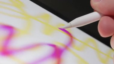 Hızlı el hareketlerinin bir tablet üzerine karalama yaparken yakın plan hızlı ve dinamik dijital çizim sergiliyor.