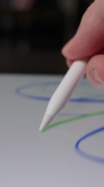 Dijital ekrana rastgele çizimler yapan, tablet üzerinde yaratıcı ve spontane çizimler yapan bir stilus kalem karalaması yakın plan.