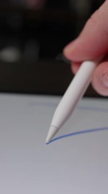 Dijital tablet ekranda rastgele mavi karalamalar oluşturmak için stil kalem kullanan bir elin yakın plan görüntüsü