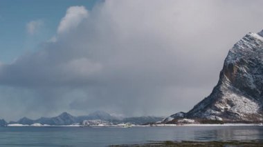 Kuzey Kutbu sularının manzaralı durgunluğu, Norveç 'in görkemli karla kaplı zirveleriyle harmanlanarak, İskandinav kışının güzelliğini yakalıyor.