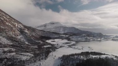Karla kaplı tepeleri ve Norveç 'in görkemli donmuş manzarasını gösteren çarpıcı bir hava manzarası kutup kışının dingin güzelliğini yansıtıyor.