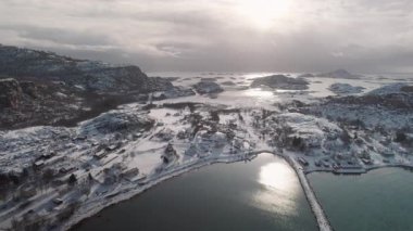 Karla kaplı el değmemiş bir araziyle çevrili bir Norveç kasabasının çarpıcı hava manzarası, kış manzarasının dingin güzelliğini yansıtıyor.