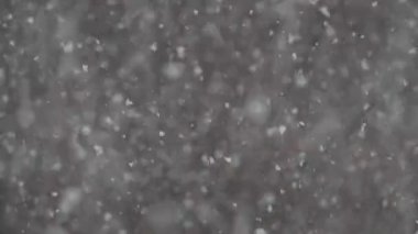 Narin kar taneleri soğuk kış havasında yavaşça sürüklenerek barışçıl ve büyülü bir atmosfer yaratır.