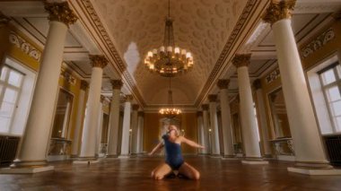 Genç bir kız topuklularla zarif bir şekilde dans ediyor, zarif hareketleri etrafındaki güzel balo salonunu büyülüyor.