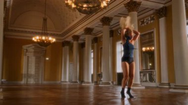 Genç bir kadın klasik mimari ile zarif, çağdaş bir dans sergiliyor. Sıvı hareketleri ve zamansız güzelliği harmanlıyor.