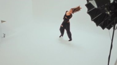 Dinamik çağdaş dans hareketleri, parlak, minimalist beyaz bir odada akıcılık ve dışavurumsal enerji gösteren genç bir kız tarafından yapılmıştır.