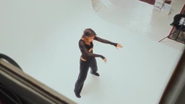 Siyahlı genç bir kızın yaptığı dinamik ve zarif bir çağdaş dans gösterisi.