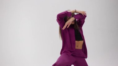 Yetenekli bir genç sanatçı zarif, minimalist bir stüdyoda büyüleyici bir modern dans gösterisi sunar. Renk değiştiren kıyafetler giyerek dinamik bir yetenek katar.