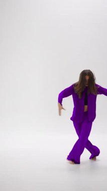 Bir genç dansçı, her hareketinde renk değiştiren termokromik giysiler giyerek zarif bir şekilde içeride performans sergiliyor ve dinamik performansını arttırıyor.