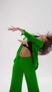 Çağdaş bir dansçı dinamik renk değiştiren bir kıyafetle akışkan hareketler sergileyen etkileyici ve sanatsal bir koreografi sergiler.