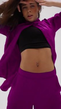 Genç bir dansçı, renk değiştiren renkli bir gardıropta minimalist bir stüdyonun arka planına karşı anlamlı ve duygusal bir gösteri sergiliyor.