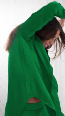 Neşeli bir bayan dansçı renk değiştiren bir kıyafet içinde minimalist beyaz bir stüdyoya hayat ve hareket getiriyor.