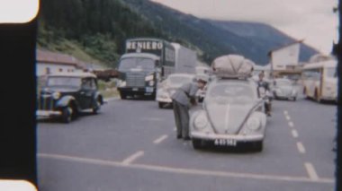 8mm 'lik klasik bir araç görüntüsü, turistlerin popüler bir turizm merkezine doğru yola çıktıkları bir kontrol noktasında diziliyor.