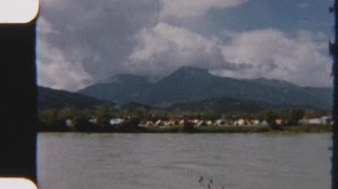 Garda Gölü 'ndeki kalabalık bir çadır kampının büyüleyici panoramik dağ manzarasıyla çevrili 8mm' lik klasik görüntüleri.