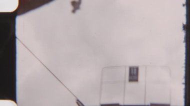 8mm 'lik vintage POV kamera arkası dramatik bulutlu bir gökyüzü olan bir tabelaya doğru bakan hareketli bir sandalyeden, sakin ve yükselmiş bir anı yakalıyor.