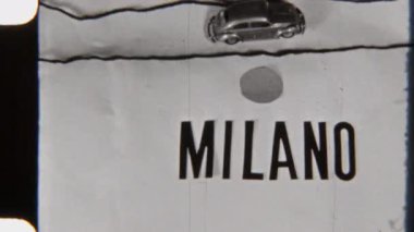 Minimalist bir haritada seyahat eden bir oyuncak arabanın 8mm 'lik klasik görüntüleri, Milano' yu hedef olarak gösteriyor.