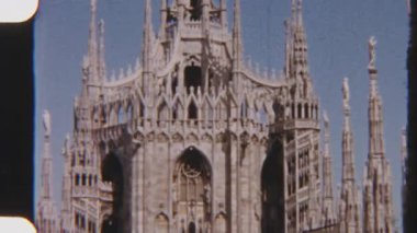 8mm 'lik klasik film Milan Katedrali' nin eğik çekimini çekiyor. Karmaşık Gotik kulelerini sergiliyor ve kulenin tepesindeki altın Madonnina heykelinde son buluyor.