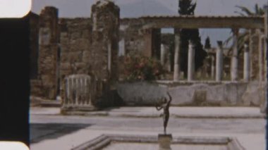 Antik Pompei 'deki Faun Evi' nde, Roma mimarisi ve sanatının arkeolojik alandaki ihtişamını vurgulayan bronz bir faun heykeli yer alıyor.