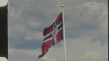 Norveç posta bayrağının açık havada dalgalanan 8 mm 'lik kareli görüntüleri tarih ve ulusal kimlik duygusunu yakalıyor.
