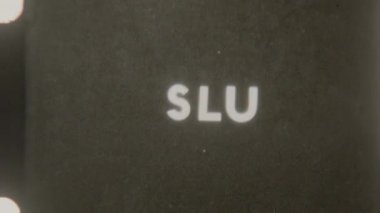 A vintage film ending featuring the word Slut with each letter appearing sequentially on a solid black background, creating a classic retro effect