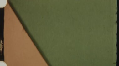 KE logosuna giden 8 mm 'lik bir retro film geçişi, aşağıda gösterilen metin Movie Pictures Sunar, desenli kırmızı bir zemin üzerine kuruludur.