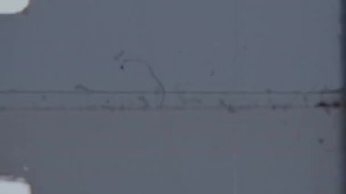 Görüntü yönetmeninin logosunun ortaya çıkmasına yol açan arızalı bir geçiş, 8 mm 'lik kırmızı bir arka plan, klasik ve sinematik bir his yakalıyor.