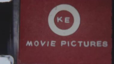 Eksik efektlere ve kumlu dokuya sahip 8mm 'lik klasik bir film, kırmızı film arka planında bir görüntü yönetmeni logosu sergiliyor