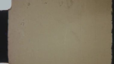 Bir görüntü yönetmeni logosu sorunsuz bir şekilde arızalı, kumlu, 8 mm 'lik kırmızı bir arkaplanda belirir ve klasik, sinematik bir dokunuş ekler.